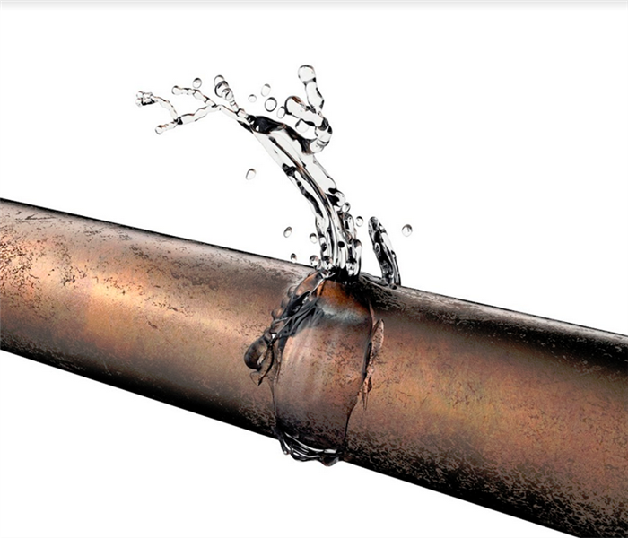 water leaking out of a burst copper pipe