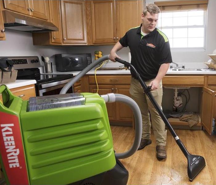 SERVPRO technician removing water in kitchen