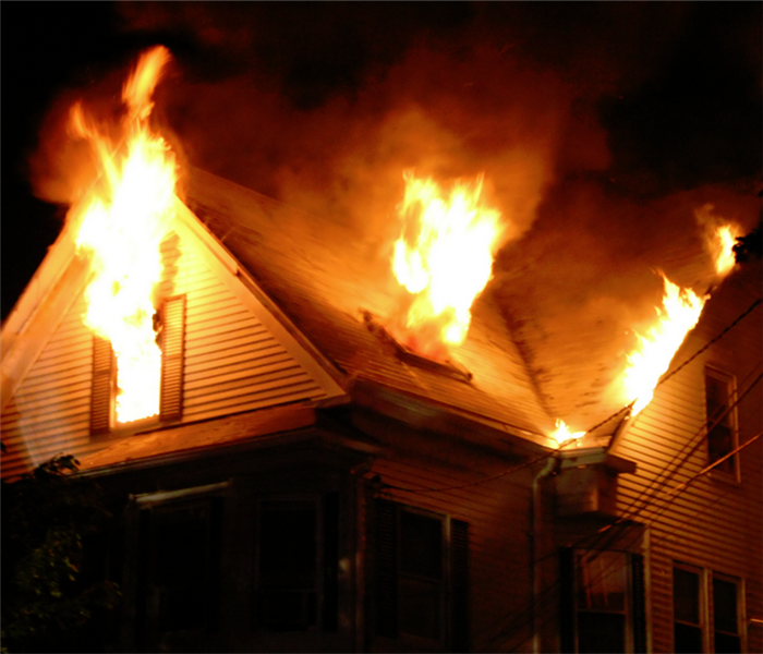 fire bursting from the windows of a house on fire